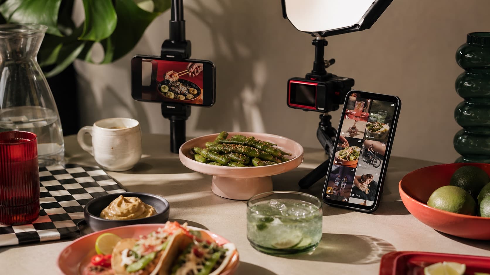Set de contenu social autour d'une table, avec plats, téléphones et éclairage studio.
